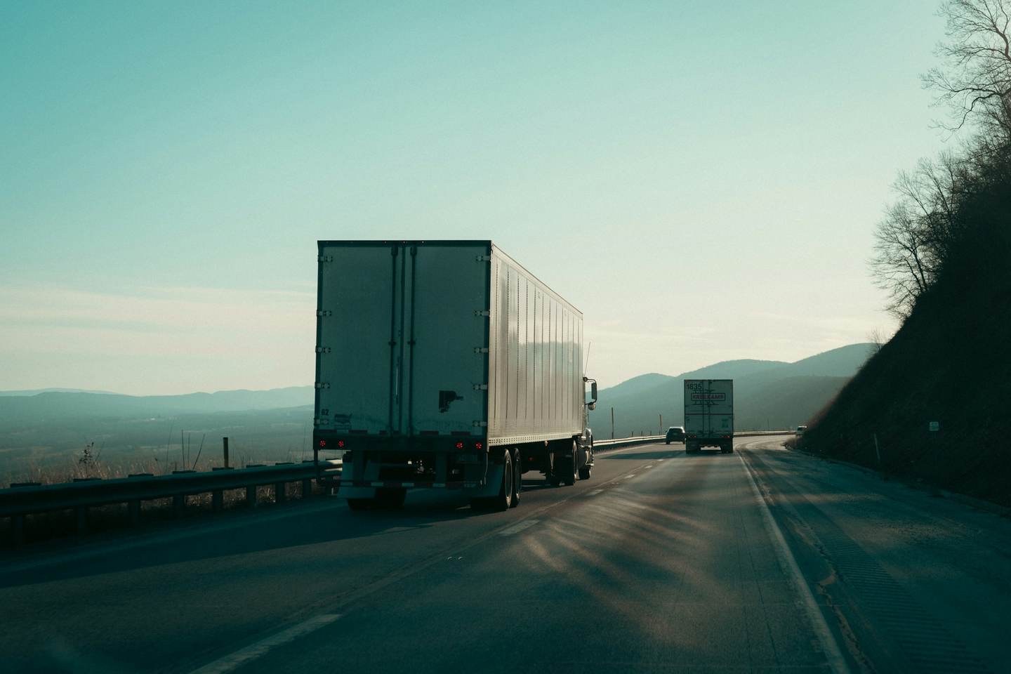 An unmarked 53-foot dry van trailer on an interstate highway